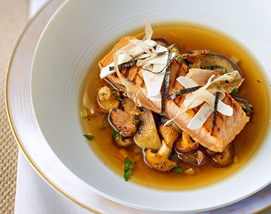 Broth with mushrooms and a salmon fillet